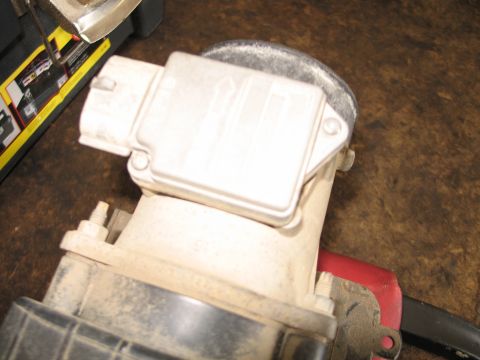 1995 Ford Bronco - A dusty mass airflow sensor is shown close-up, disconnected from a vehicle.