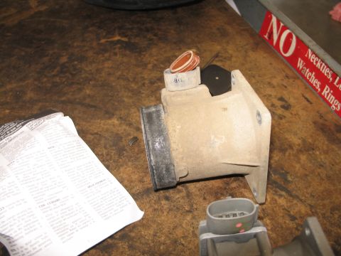 1995 Ford Bronco - Mass air flow sensor part with associated gaskets and connector, next to installation instructions.