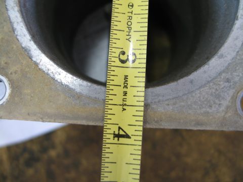 1995 Ford Bronco - A measuring tape is used to show the dimensions of a metal part, possibly a MAF sensor housing.