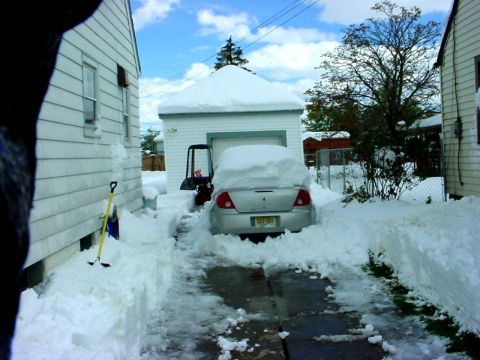 1973 Ford Ranchero - A car is buried in snow, with a snowblower nearby, suggesting a recent snowfall.