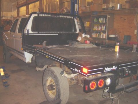 1992 Ford Bronco - A flatbed truck with a HydraBed conversion is shown in a workshop setting.