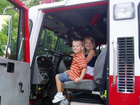 1986 Ford Bronco - Two smiling children sit in the driver's seat of a fire truck.