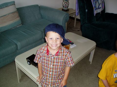 1986 Ford Bronco - A young boy sits indoors next to a toy car on a coffee table.