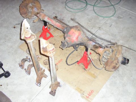 1996 Ford Bronco - Vehicle rear axle and suspension components are laid out on cardboard.