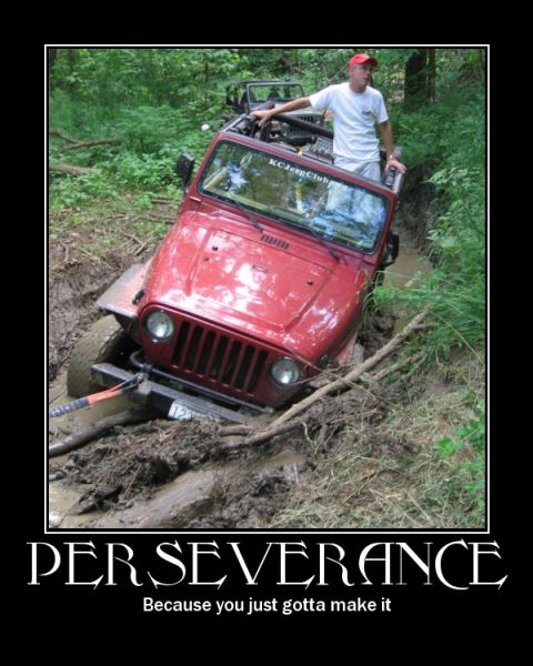 1998 Jeep TJ - A red 1998 Jeep TJ is stuck deep in mud on a wooded trail, with another Jeep behind it.