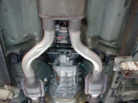 1993 Ford Thunderbird - Underside view of a vehicle's exhaust system, dual catalytic converters and the transmission assembly.