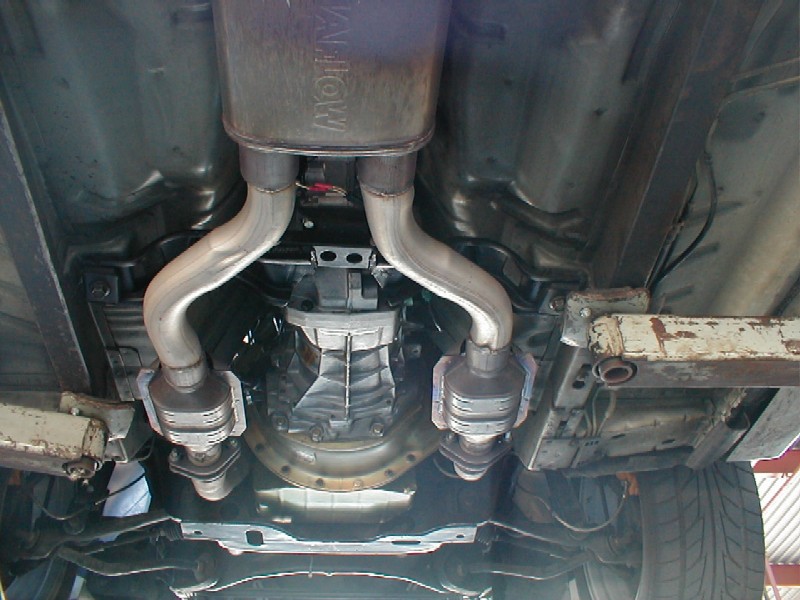 Underside of a car showing the transmission and dual exhaust system with catalytic converters