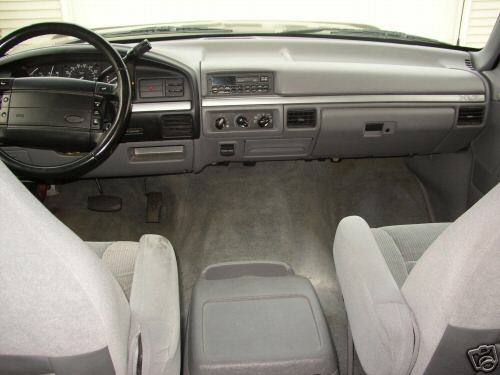 Gray interior dashboard and bench seats of an older Ford truck
