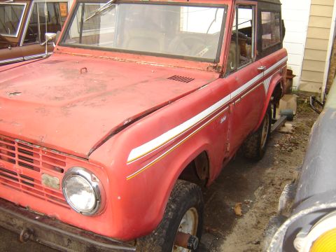 2006 Ford F1 - This classic SUV is red with white side stripes and appears to be a 1977 model.