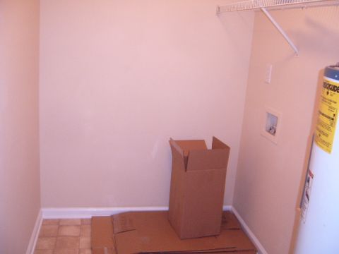 1988 Ford Bronco - Interior view of a laundry room a water heater, cardboard boxes, and a wire shelf.
