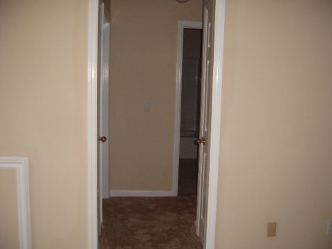 1988 Ford Bronco - A view down a hallway with carpet and two open doors, one revealing a bathroom.