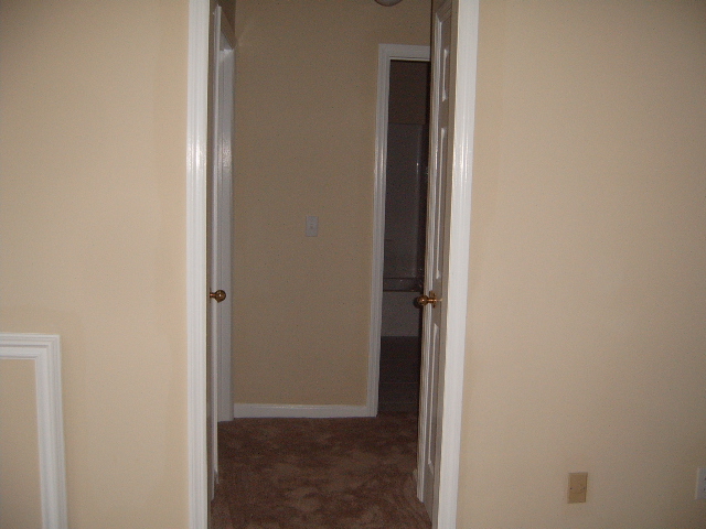 Interior hallway with two doors open, one leading to a bathroom