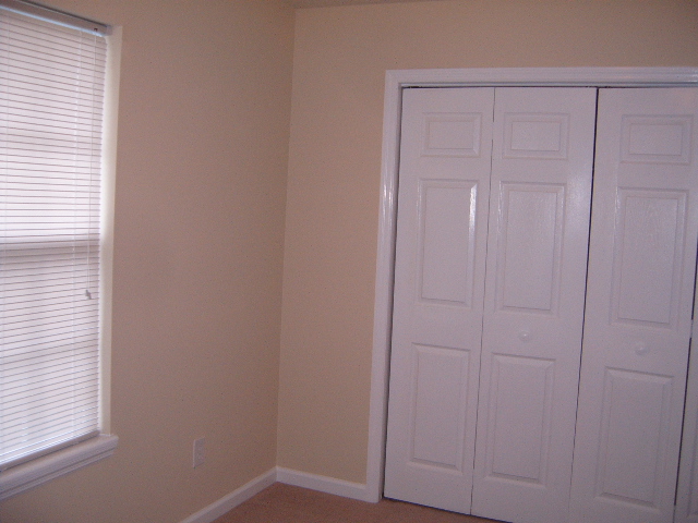 Interior room with blinds on window and bi-fold closet doors. Watermark says SUPERMOTORS