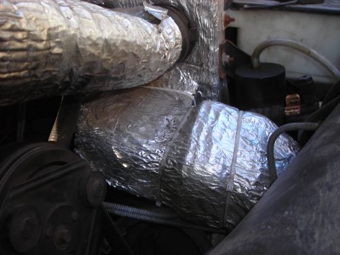 1995 Ford Bronco - Close-up view of insulated hoses and engine components in a vehicle's engine bay.
