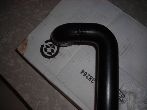 1995 Ford Bronco - Close-up of a black metal pipe on a cardboard box with visible markings.