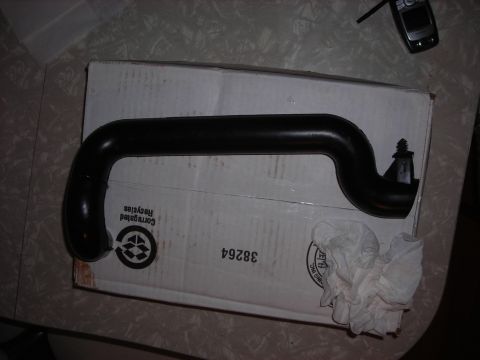 1995 Ford Bronco - A black rubber hose is placed on a cardboard box, with a cell phone visible in the background.