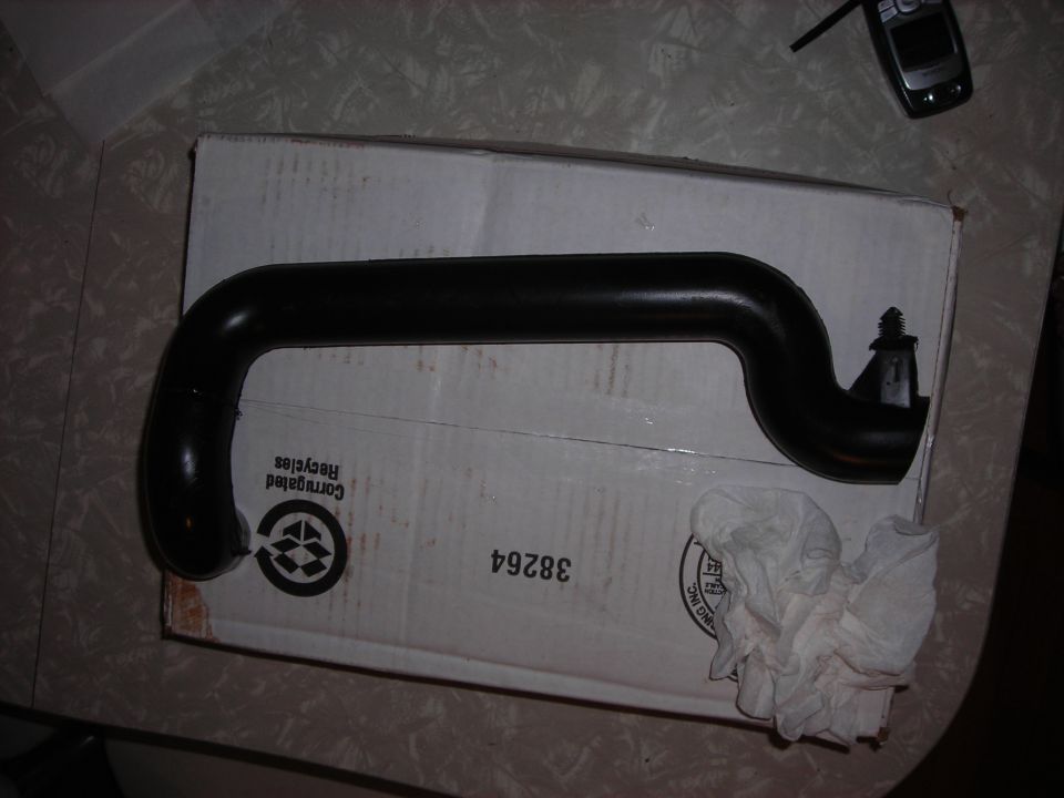 Black rubber hose on a cardboard box with some crumpled paper