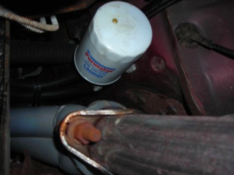 1995 Ford Bronco - Close-up of an oil filter and exhaust pipe, likely from a vehicle's undercarriage.