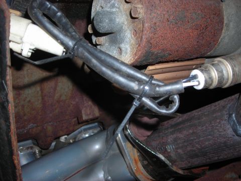 1995 Ford Bronco - A close-up view of a vehicle's exhaust system, focusing on a sensor and associated wiring.
