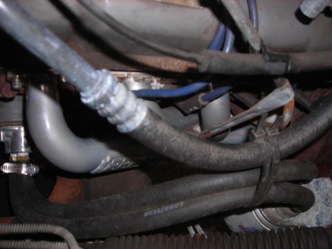 1995 Ford Bronco - Close-up view of vehicle exhaust pipe and various hoses, including a Goodyear branded hose.
