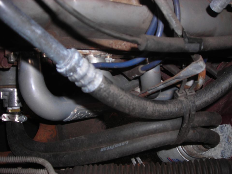 Close-up of exhaust pipe and hoses with a Goodyear hose visible