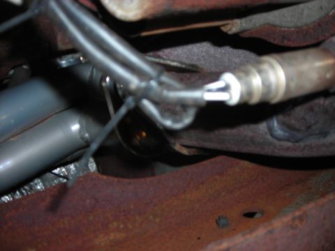 1995 Ford Bronco - A close-up view of an exhaust system component, likely an oxygen sensor, with associated wiring.