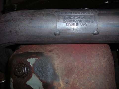 1995 Ford Bronco - Close-up of an exhaust system part, showing a manufacturer's label and rusted components.