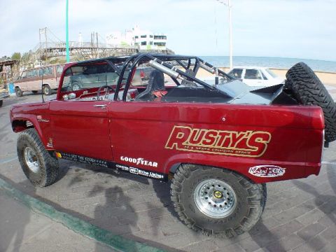 1977 Ford Bronco - This modified 1977 Ford Bronco features a prominent roll cage and custom "Rusty's" branding on its side.