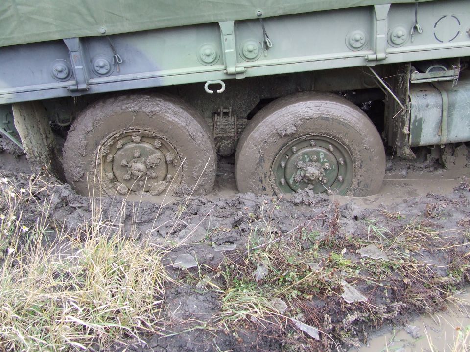 Military truck wheels stuck deep in mud