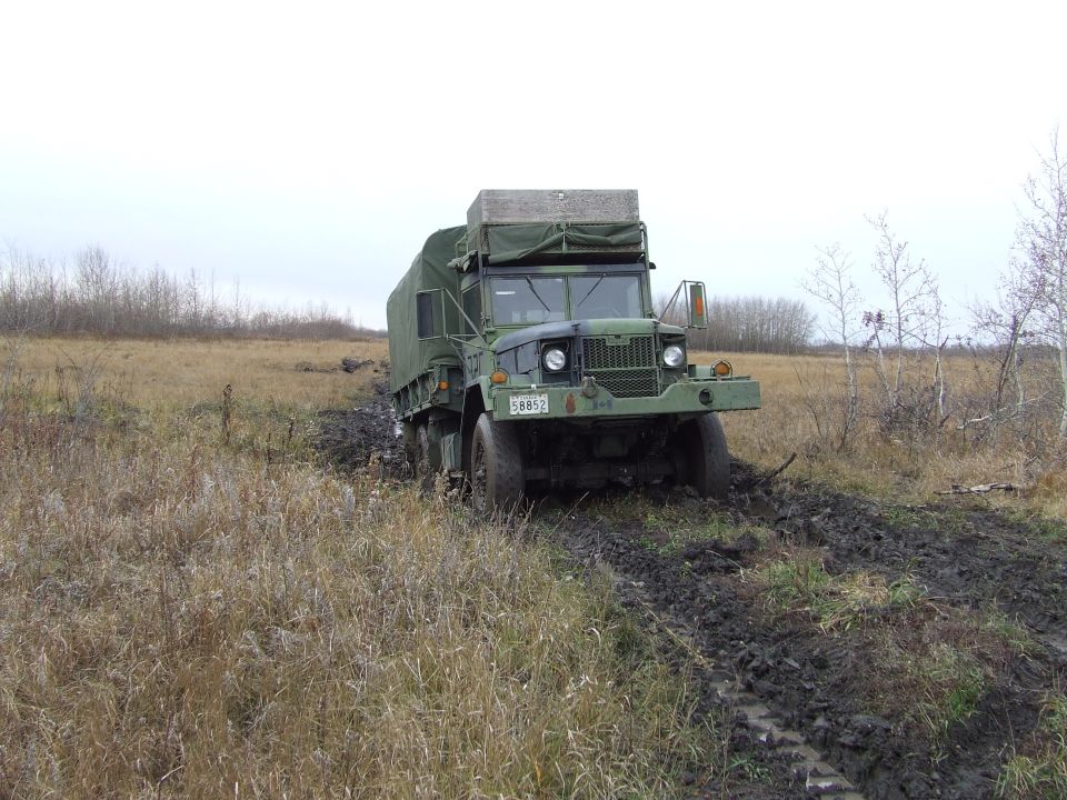 Green military truck with license plate 58852 stuck in muddy terrain