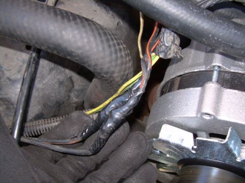 1988 Ford Bronco - Close-up view of alternator wiring, showing taped connections and various colored wires.