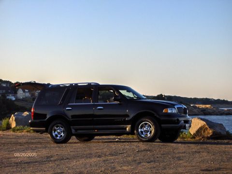 1996 Mercury Grand Marquis - A black SUV is parked near the ocean with its rear hatch open, under a clear sky. The date 08/26/2005 is visible.