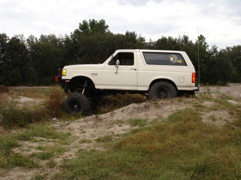 1989 Ford Bronco - This lifted 1989 Ford Bronco is shown in a side profile, navigating an off-road terrain.