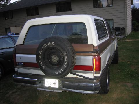 1987 Ford Bronco - Rear view of a 1987 Ford Bronco, showing its spare tire and two-tone paint.