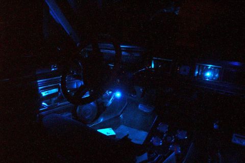 1985 Ford Crown Victoria LTD - The interior of a car is illuminated by blue LED lights, casting a glow on the dashboard and steering wheel.