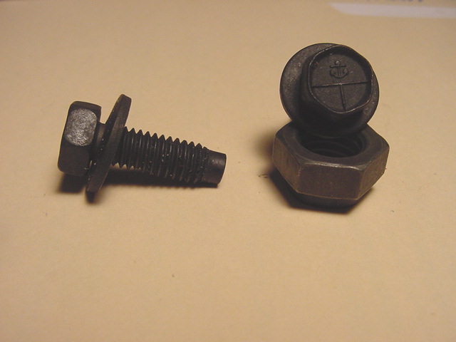 Two black hex-head bolts with washers on a tan surface