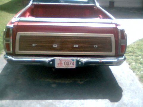 1970 Ford Ranchero - The rear of a red 1970 Ford Ranchero shows its distinctive woodgrain tailgate panel and chrome bumper.