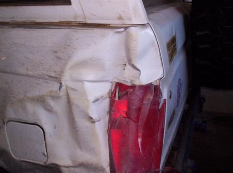 1995 Ford Bronco - The rear of a white SUV shows significant damage to the quarter panel and tail light.