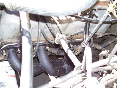 1991 Ford Bronco - Close-up view of engine components, including the exhaust manifold and various hoses.