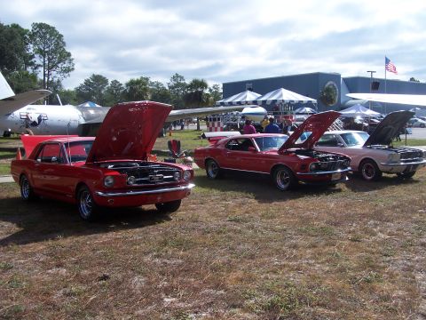 1973 Ford Ranchero - A trio of classic Ford Mustangs are displayed with their hoods open at an outdoor event.