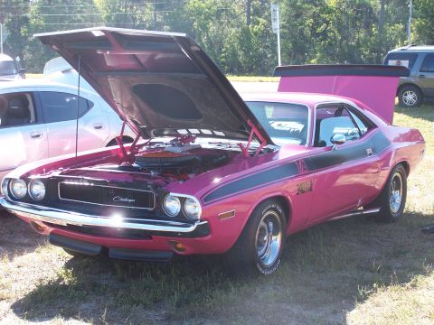 1973 Ford Ranchero - This pink 1973 Dodge Challenger features black racing stripes and a prominent rear spoiler, with its hood open to reveal the engine.