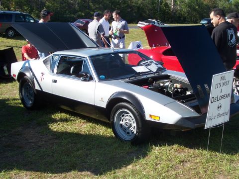 1973 Ford Ranchero - A De Tomaso Pantera is displayed at a car show, with a sign clarifying it is not a DeLorean.