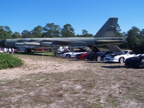 1973 Ford Ranchero - A car show is held outdoors with a large bomber aircraft as a backdrop.
