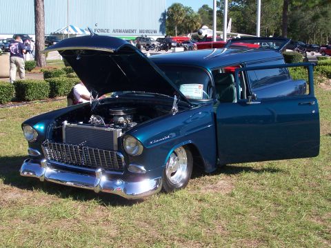 1973 Ford Ranchero - A classic blue panel van sits on grass with its hood and driver's door open.
