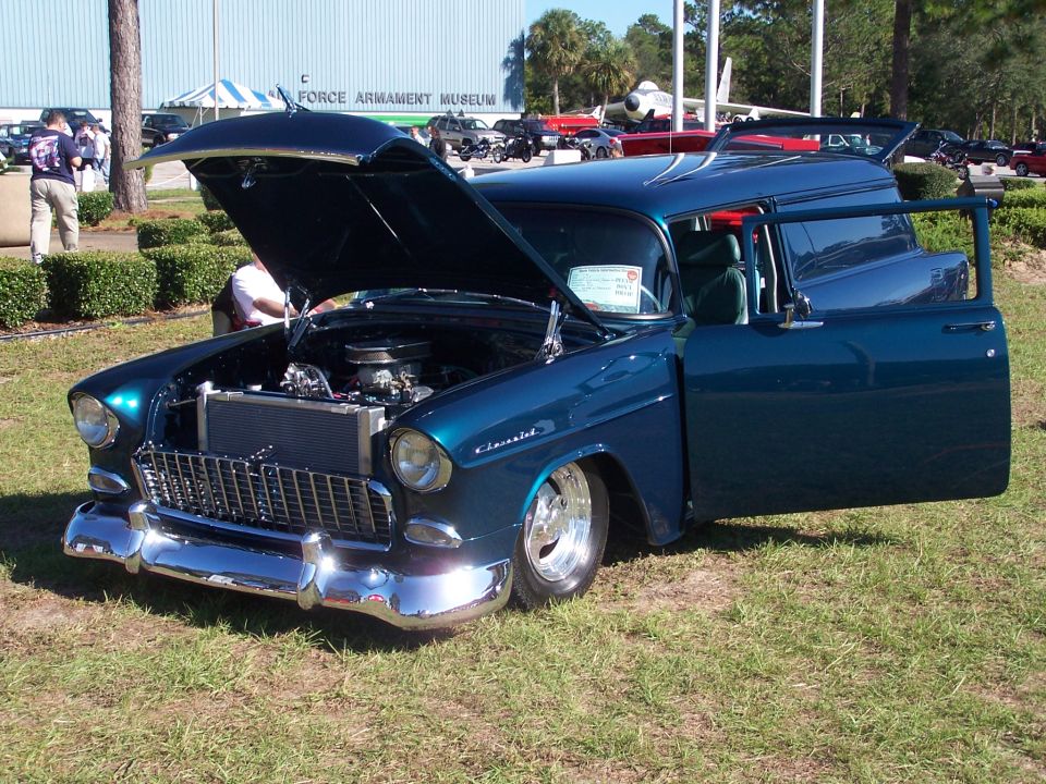 Blue panel van with hood and driver's door open, showing engine and interior