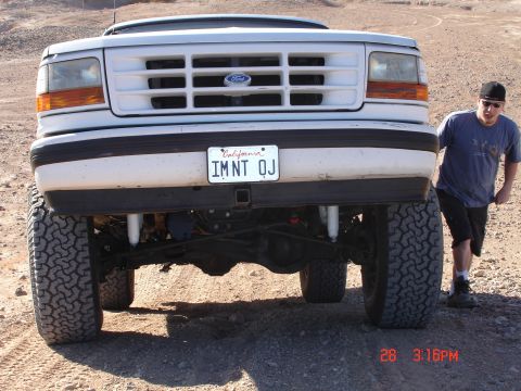 1996 Ford Bronco - Front view of a 1996 Ford Bronco with large tires and a person standing next to it.
