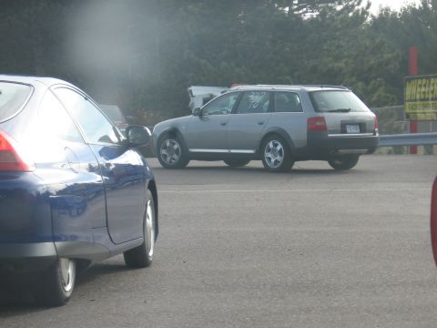 1989 Ford Mustang - A silver station wagon is seen on a track, with racing numbers visible on its window.