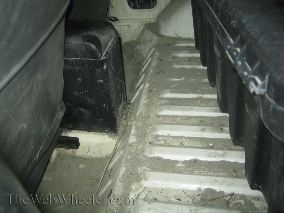Interior floor of a vehicle with ribbed metal and black plastic components