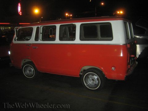1968 Ford Mustang - A two-tone red and white van is parked at night, showing its side profile with whitewall tires.