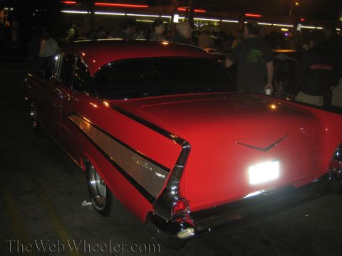 1968 Ford Mustang - Rear view of a red 1957 Chevrolet Bel Air with distinctive tail fins and chrome accents.